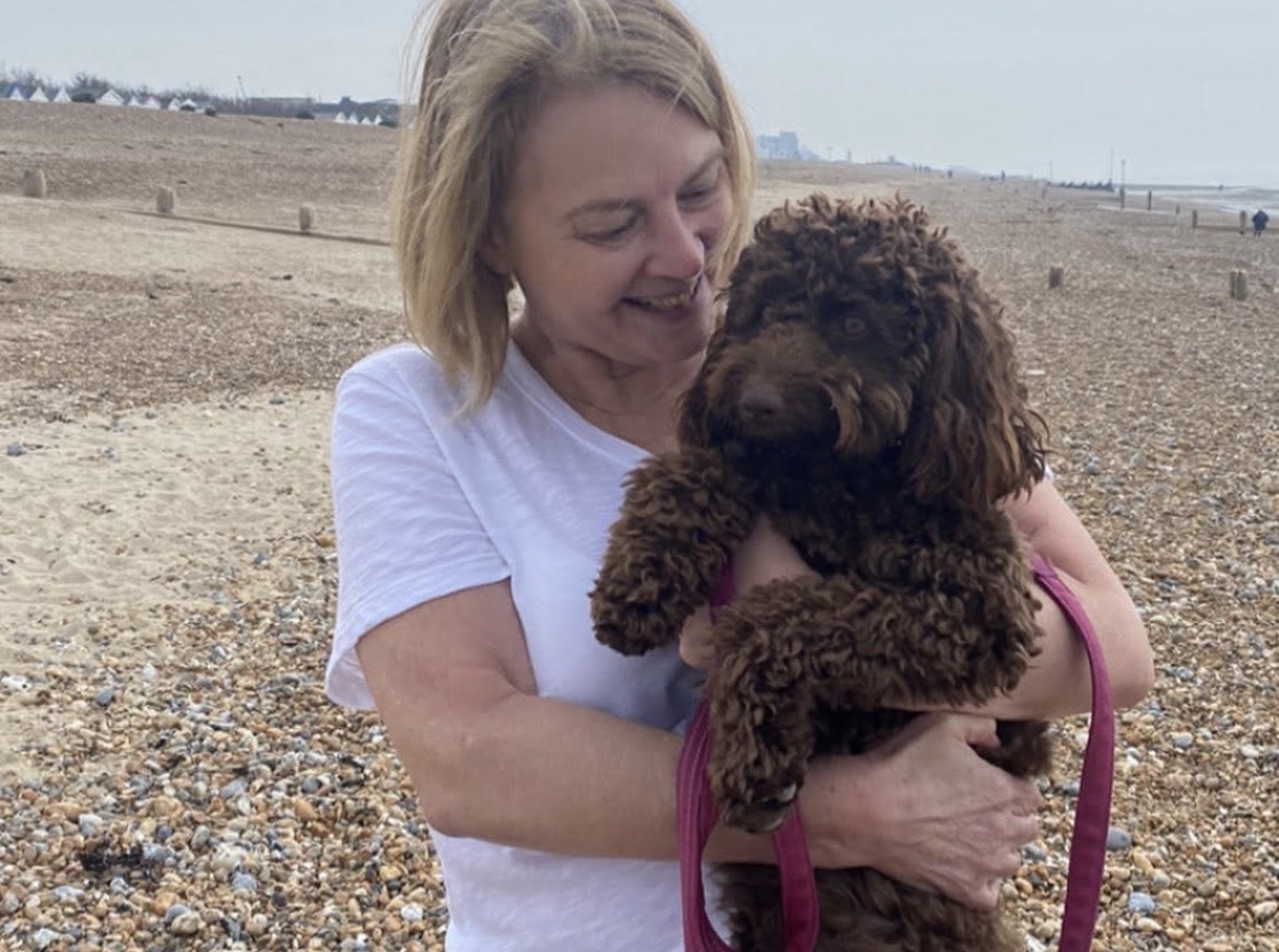 Paula Richardson holding her dog on the beach